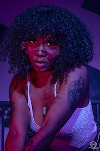 a woman with tattoos posing on a bed