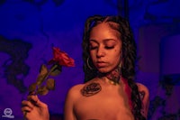 a woman with tattoos holding a rose