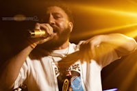 a man with a beard singing into a microphone