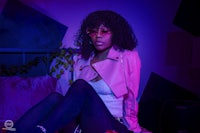 a woman in a pink jacket sitting on a bed