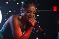 a woman in a blue dress singing into a microphone