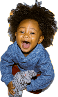 a black child laughing with a teddy bear