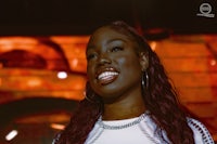 a black woman smiling in front of a red light