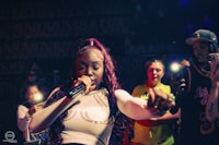 a woman singing into a microphone in front of a crowd