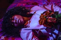 a woman laying on a bed with a bouquet of roses