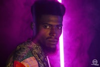 a man with a beard in front of a purple light