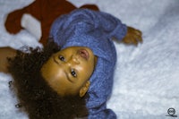 a child laying on a white blanket