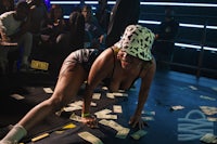 a woman in a hat laying on the floor with money