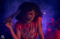 a woman holding a knife in front of a red background